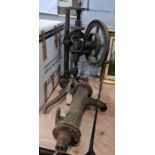Old hand-cranked pillar drill and a cast iron water pump