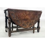 Late 19th century oak gateleg table, the top with carved decoration, on turned and block legs,