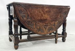 Late 19th century oak gateleg table, the top with carved decoration, on turned and block legs,