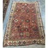 Red ground rug, possibly Persian, and possibly circa 1860, with allover hooked arabesques and