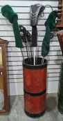 Quantity various golf clubs in red and black painted metal stickstand