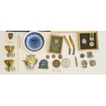 Collection of military badges, a military-style pocket compass, brass trench art, an AA car