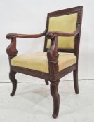 Regency mahogany elbow chair, the square back having stiff leaf carved open scroll arms, cream