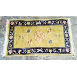 A Chinese wool rug, cream yellow ground with blue border decoration with blossom; measurements 149/