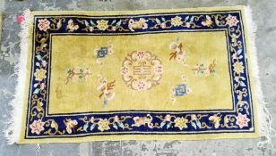 A Chinese wool rug, cream yellow ground with blue border decoration with blossom; measurements 149/