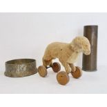Brass shell case, large brass artillery shell base and a vintage straw-stuffed small toy dog on