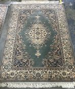 A Persian style wool rug: a royal Keshan rug wool, light green blue ground central foliate medallion