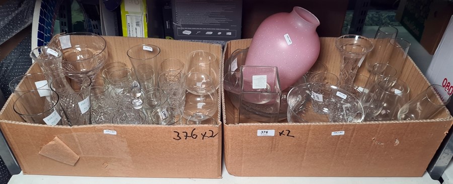 Two boxes of mixed glasses including champagne flutes, beer glasses and a large pink opaque vase