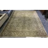 A large Persian style wool rug, yellow cream ground, all over brown floral decoration and border.