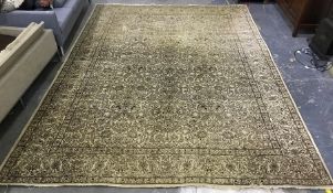 A large Persian style wool rug, yellow cream ground, all over brown floral decoration and border.