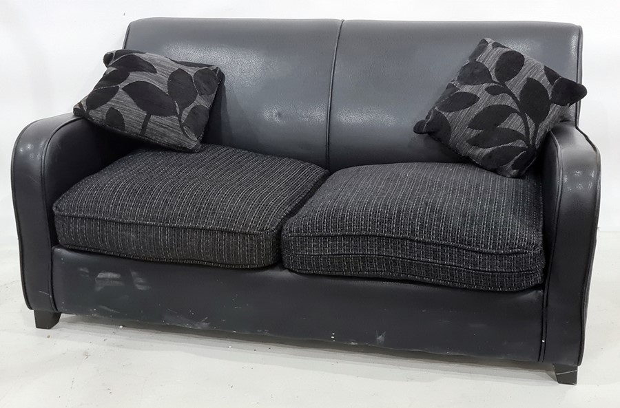 Modern black leather two-seater sofa bed with two scatter cushions
