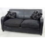 Modern black leather two-seater sofa bed with two scatter cushions