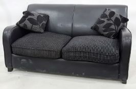 Modern black leather two-seater sofa bed with two scatter cushions