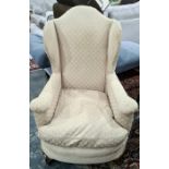 Early 20th century wingback armchair with cream ground upholstery, squat claw and ball front legs