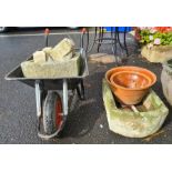 Gardeners wheelbarrow containing D-end stone trough and four stone cornice pieces, another D-end