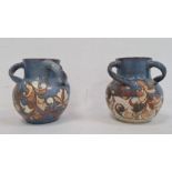 Pair H Brannam Barum glazed terracotta three-handled vases, each foliate decorated on a blue ground,