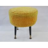 Mid-20th century circular padded stool on ebonised tapering supports with yellow covering, 42cm