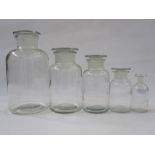 Set of five graduating pharmaceutical clear glass lidded jars and a French pottery oil pourer in the