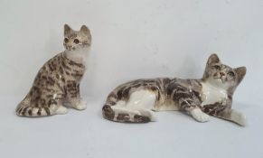 Large Winstanley reclining tabby cat, 41cm long approx and another seated, 25cm high (2)