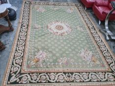 Large green rug with central foliate medallion, foliate spandrels, stepped foliate border, 421cm x