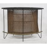 20th century bowfront bar with plain black top, with grill front, three shelves and brass tubular