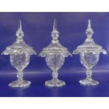 Set of three 19th century cut glass sweetmeat jars with covers, pointed finials , waisted stem on