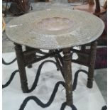 Indian table with brass tray top, dished centre, heavily carved folding base