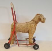 Push-a-long straw-stuffed dog on wheels, 49cm high, worn