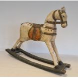 Painted wooden rocking horse, the white horse with  saddle and bridle on green highlighted