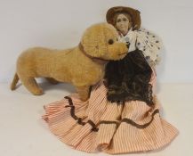 Early 20th century dachshund soft toy and a doll with fabric painted face, straw hat, spotted