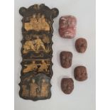 Four small Japanese pottery masks with grotesque expressions, another larger plaster mask and a