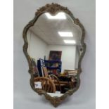 Gilt wall mirror of cartouche-shape with floral gilt decoration, within a blue border, 75cm high