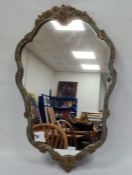 Gilt wall mirror of cartouche-shape with floral gilt decoration, within a blue border, 75cm high