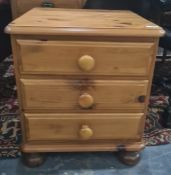 Modern pine bedside chest of three drawers, on bun feet