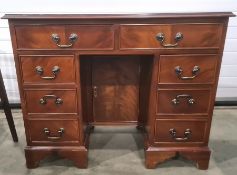 Reproduction mahogany kneehole desk with an arrangement of two long and six small drawers around the