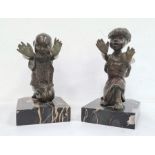 Pair of bronze and marble figural bookends each in the form of a kneeling figure with outstretched