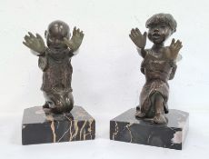 Pair of bronze and marble figural bookends each in the form of a kneeling figure with outstretched