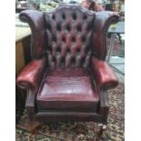 Pair of red leather button back wing back office reception armchairs, on cabriole legs (2)