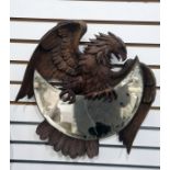 Early 20th century Black Forest mirror modelled as a carved eagle holding a crescent-shaped bevelled