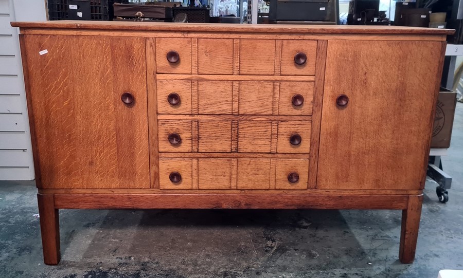 Gordon Russell oak sideboard with four central drawers flanked by cupboard doors, shaped legs,