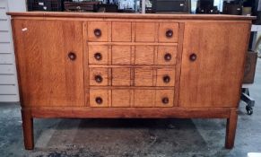 Gordon Russell oak sideboard with four central drawers flanked by cupboard doors, shaped legs,