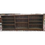 Large mahogany three-section open bookcase raised on plinth base, 289cm x 112cm