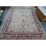 Cream ground Eastern-style rug with allover foliate design, red ground and stepped border, 400cm x