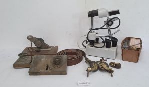 Two brass doorlocks and various castors, a box of  lead "serpent" labels, a microscope and various