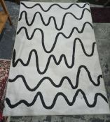 Modern rug with black undulating lines, on a white ground, 132cm x 198cm  Condition