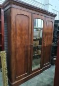 19th century mahogany compactum, the moulded cornice above three cupboard doors, the central and