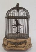 Late 19th century singing bird automaton, the bird on a perch with foliage within a wire cage and on