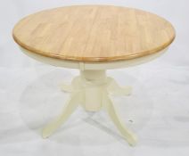Modern dining table of circular form, cream painted base