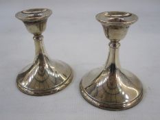 A pair of 1950s squat silver-mounted candlesticks, plain tapered form on circular bases,