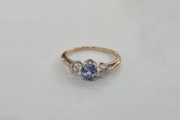 Gold-coloured metal, ceylon sapphire and diamond ring set oval sapphire to the centre flanked by two